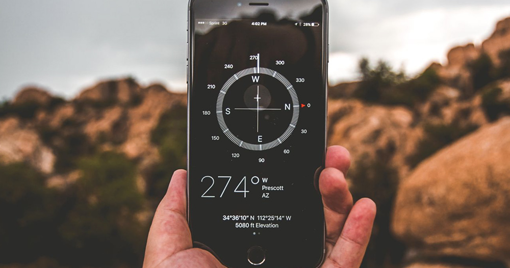 person holding a phone with latitude and longitude coordinates