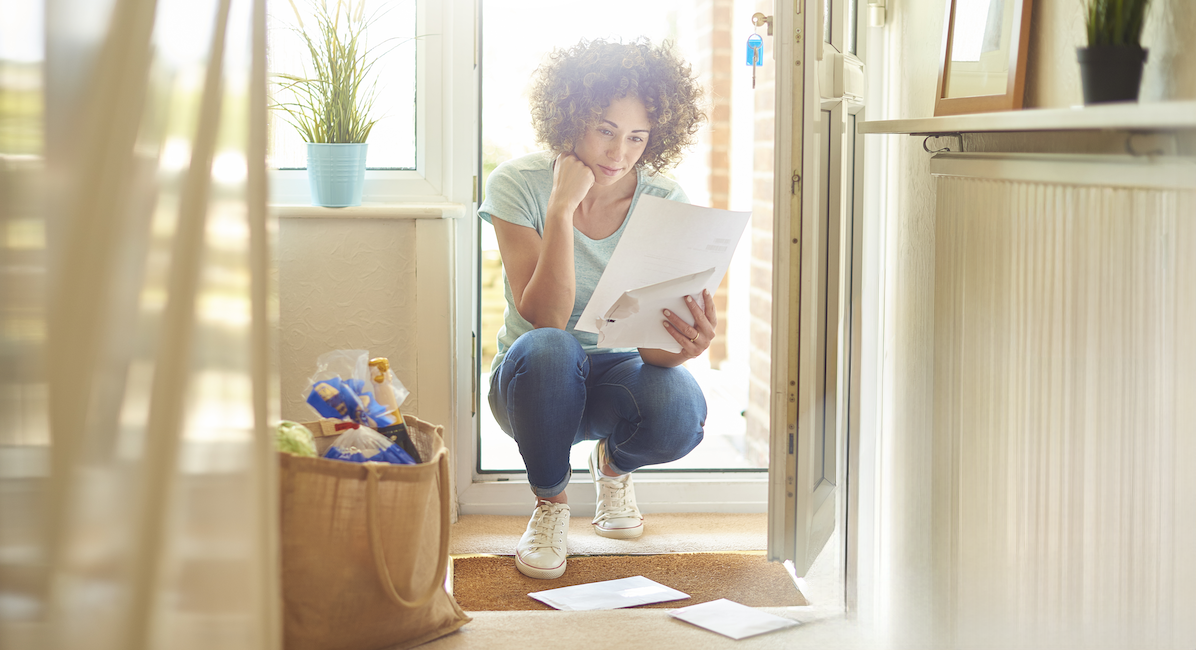 women reading a letter with mail on the ground